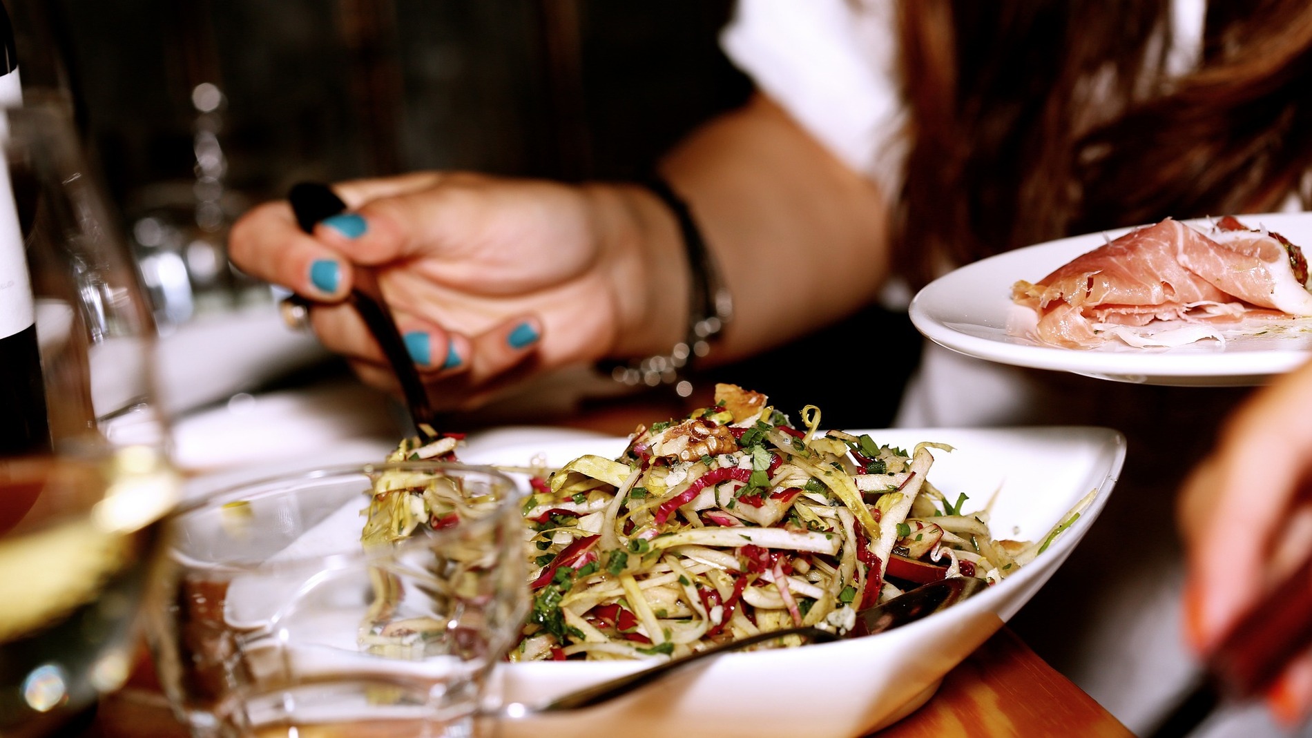recorte mano de mujer recoge ensalada de plato en restaurante